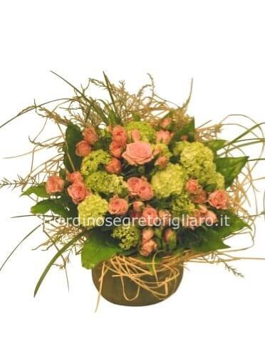 Cestino di vimini o ciotola di ceramica, composto da rose e verde pregiato.